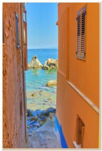 Chianalea-vicolo-e-sullo-sfondo-i-faraglioni-detti-la-Sacra-Famiglia